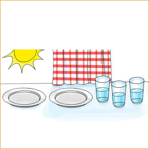 Sonne, zwei Teller, drei Gläser mit Wasser und rot-weiß-karierte Decke